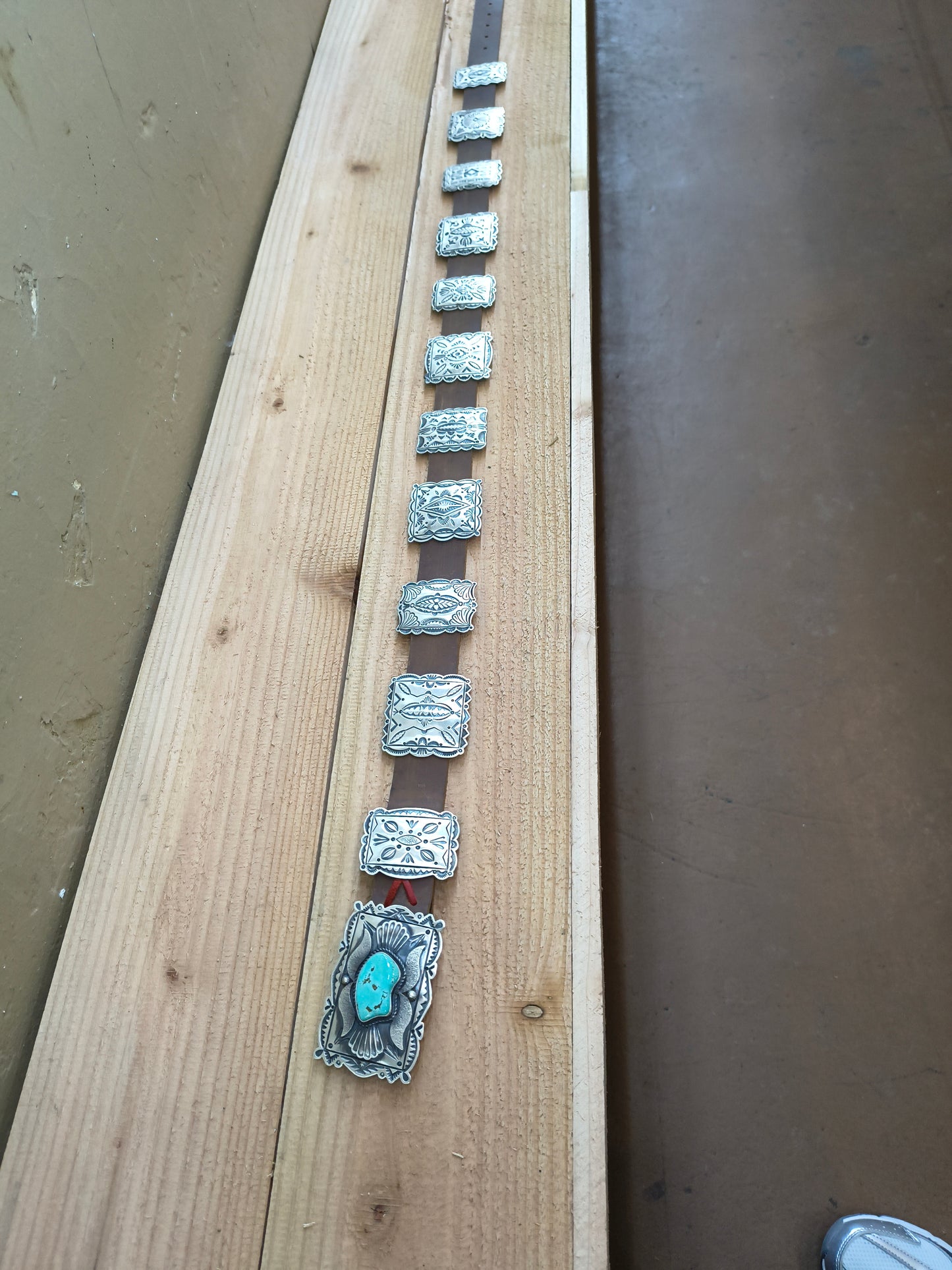 Turquoise bear belt with square conchos.