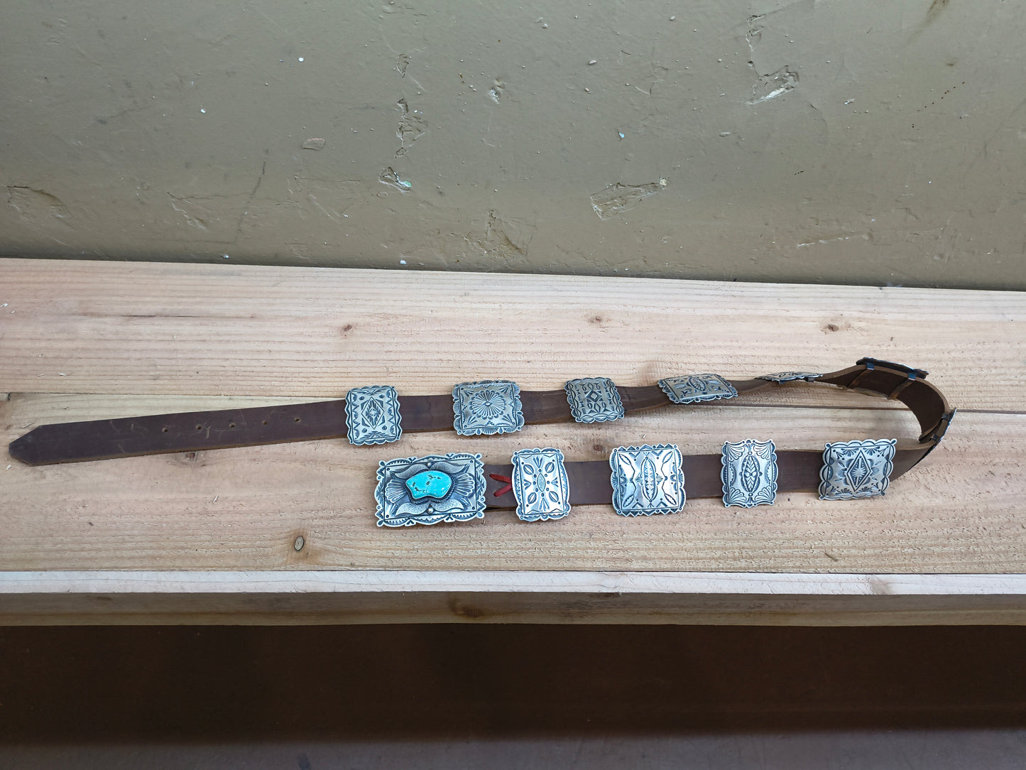 Turquoise bear belt with square conchos.